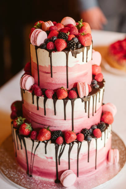 Big white and pink cake decorated with red strawberry and black